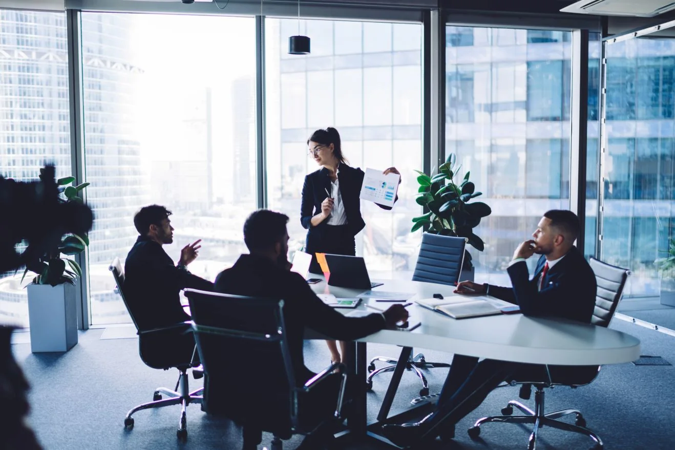 An executive presenting to a leadership team in a high-rise office